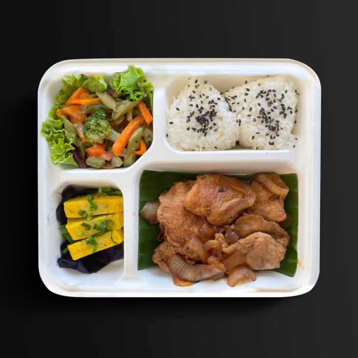 Obento japonés con cerdo salteado (buta yakiniku), arroz blanco, tamagoyaki y vegetales al vapor